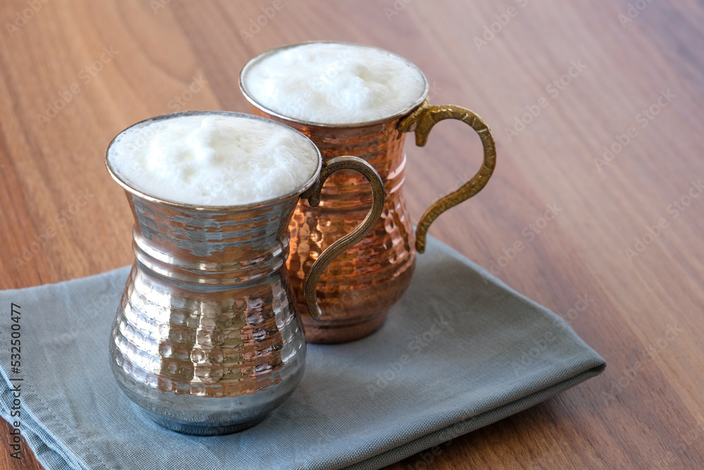 Buttermilk, Ayran Traditional Turkish yoghurt drink with foam in a copper metal cup. Sparkling