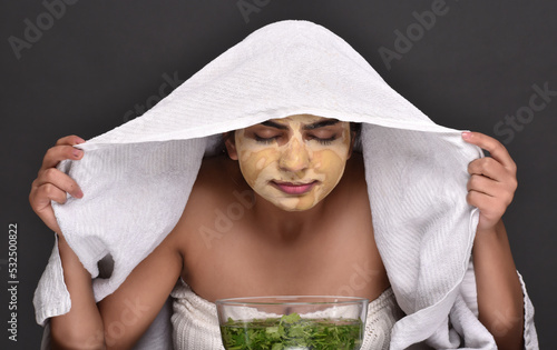 A young woman taking steam of organic leaves for skin care