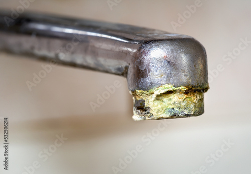 Chrome tap with unhigienic lime, calcium deposit from hard water in the kitchen photo