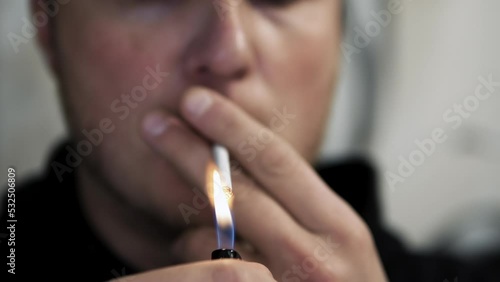 Young man smokes a cigarette. Light a cigarette with a lighter, light a cigarette photo