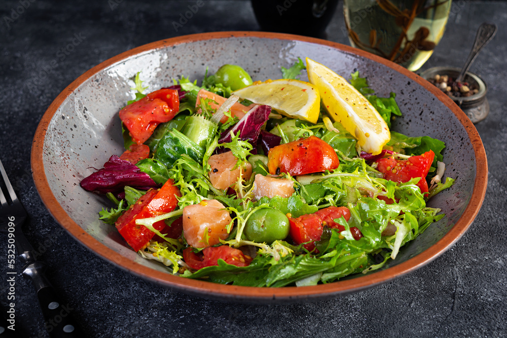 Fresh salad with salmon fish mixed with greens, tomato, olives, mustard and lemon juice Fresh salad with salmon fish mixed with greens, tomato, olives, mustard and lemon juice