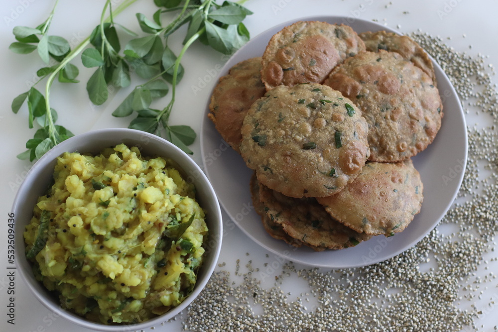 Bajra methi puri. Deep fried Indian flatbread made of pearl millet flour and fenugreek leaves. Served with spiced mashed potato gravy. Shot on white background. Bajra methi puri. Deep fried Indian flatbread made of pearl millet flour and fenugreek leaves. Served with spiced mashed potato gravy. Shot on white background.