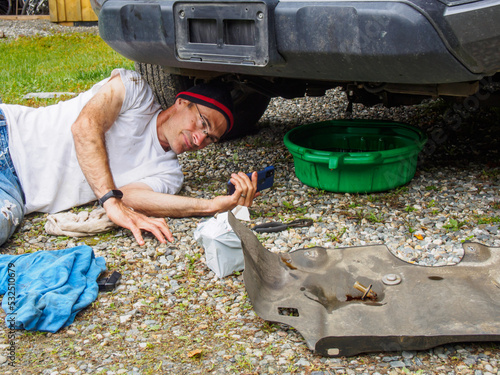 Person on phone working on car