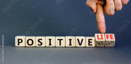 Positive thoughts and life symbol. Concept words Positive thoughts or Positive life on wooden cubes. Businessman hand. Beautiful grey background. Business positive thoughts life concept. Copy space