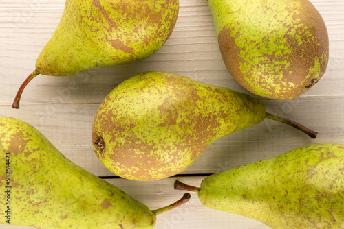 Several sweet pears on a wooden table, macro, top view.