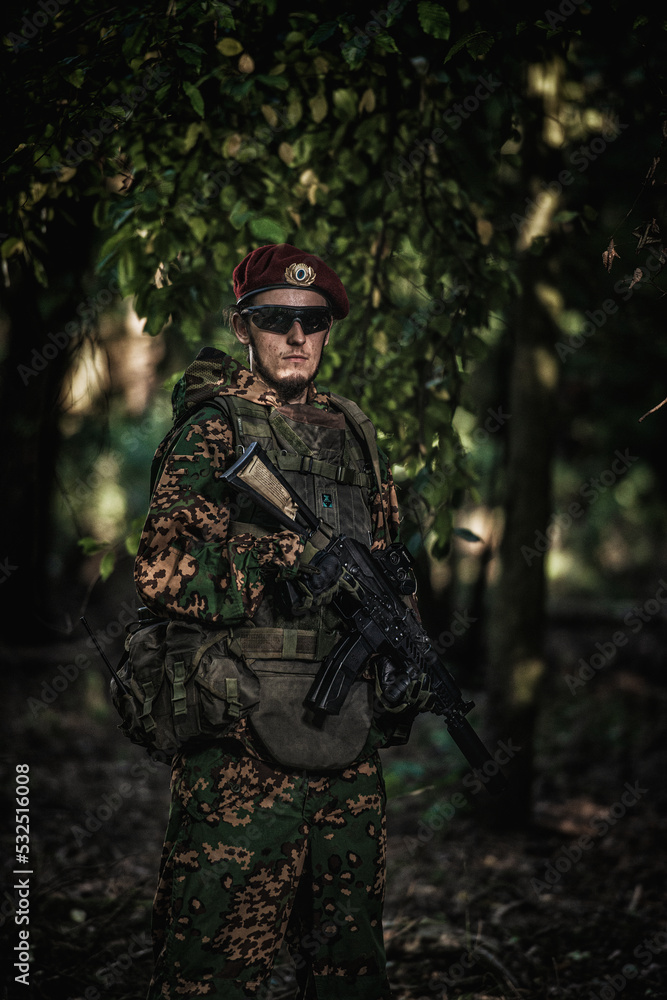 Portrait of an eastern special forces soldier with rifle in woodland ...