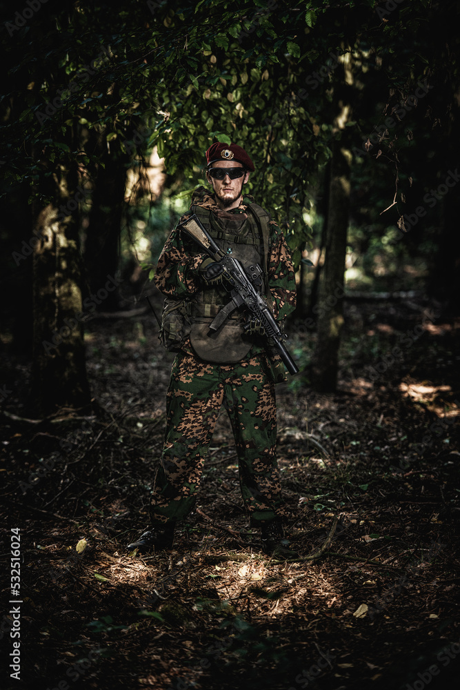 Fototapeta premium Portrait of an eastern special forces soldier with rifle in woodland