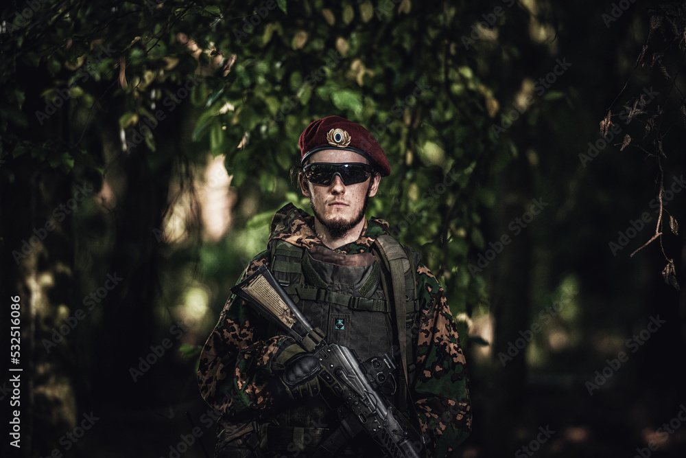 Portrait of an eastern special forces soldier with rifle in woodland