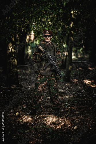 Portrait of an eastern special forces soldier with rifle in woodland