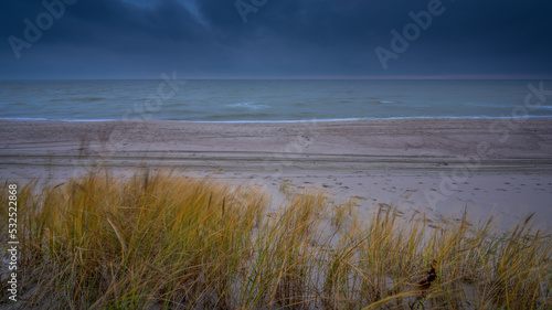 grassy dunes sea overcast heavy clouds on background