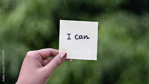 Outdoor image of I can word written on sticky note green dark blurred background.