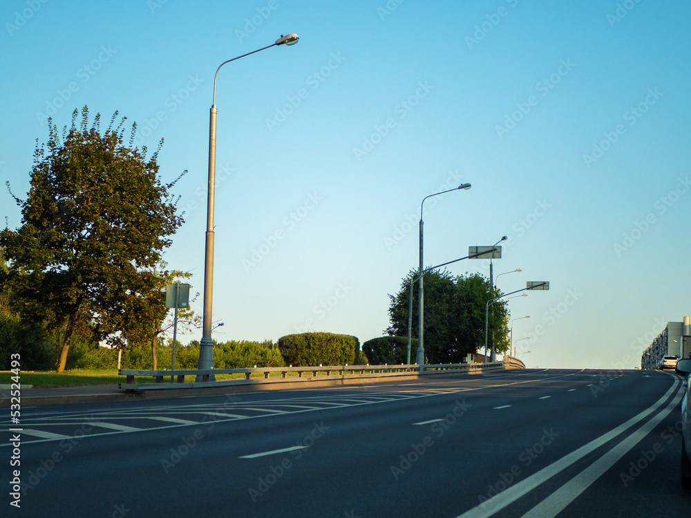 Empty highway with street lamps and road markings.