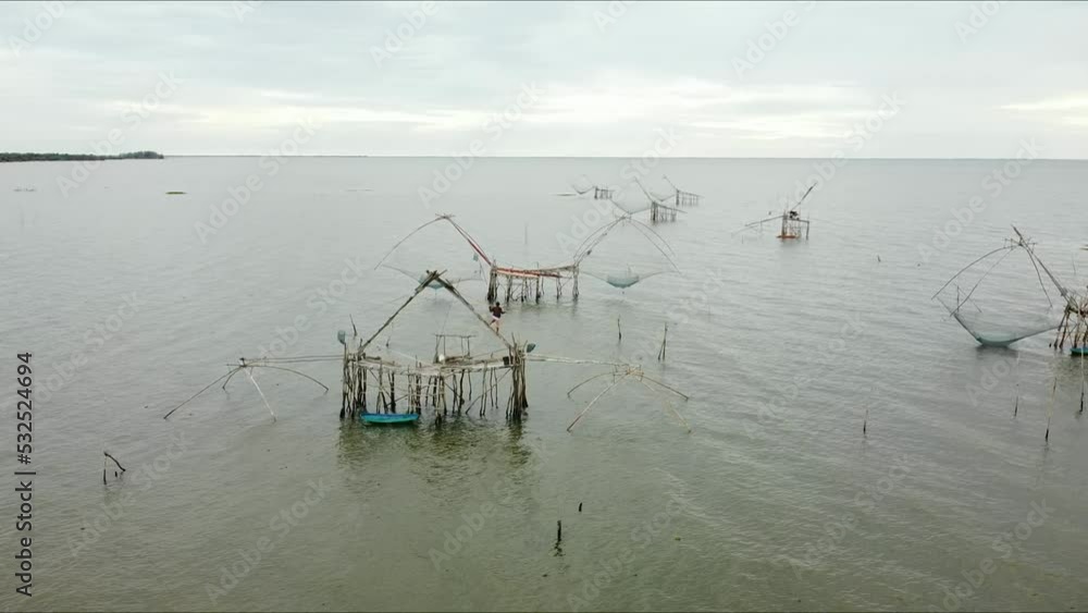 The giant fishing constructions, It is signature fishing trap and traditional fishing style of Pak Pra fishing village, Phatthalung, THAILAND. (2.7K resolution footage by drone) The giant fishing constructions, It is signature fishing trap and traditional fishing style of Pak Pra fishing village, Phatthalung, THAILAND. (2.7K resolution footage by drone)