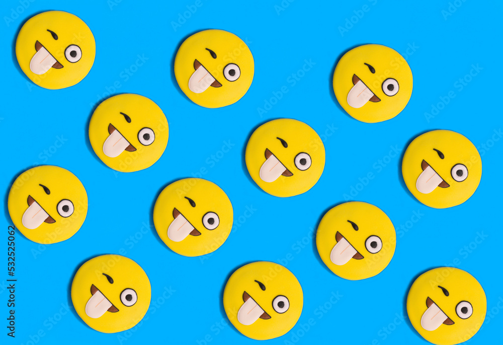 Smileys in the form of gingerbread on the blue background. Flat lay. Smileys in the form of gingerbread on the blue background. Flat lay.