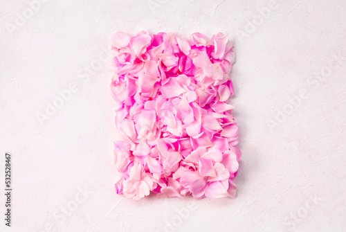 A frame made of pink rose petals on a light background. copy space .A postcard