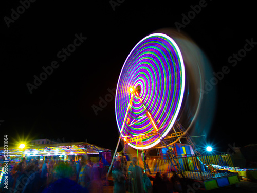 Moving light from ferris wheel at night 