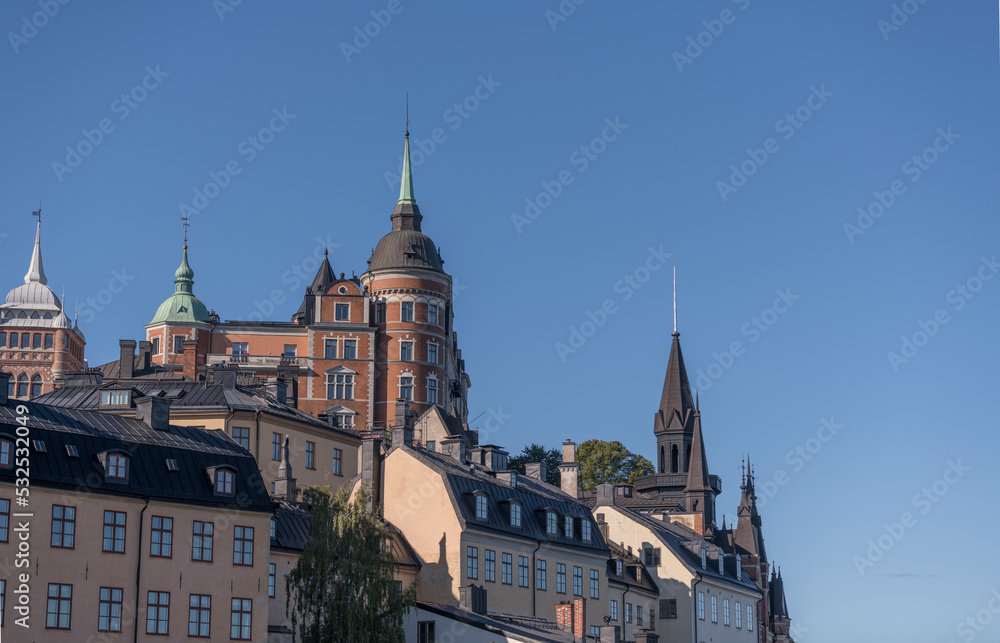 Old apartment’s houses at the street Bastugatan, tin roofs, dorms and chimneys in the district Södermalm a sunny autumn day in Stockholm