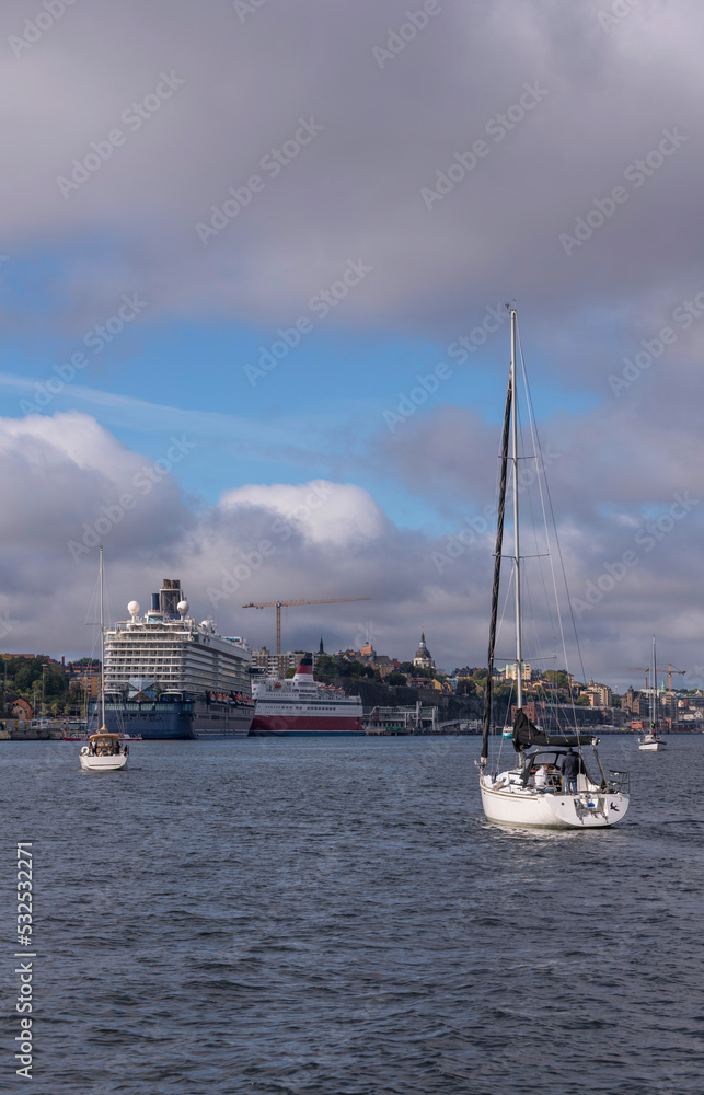 Ferries and sail boats in the bay Strömmen and cumulus clouds an autumn day in Stockholm 