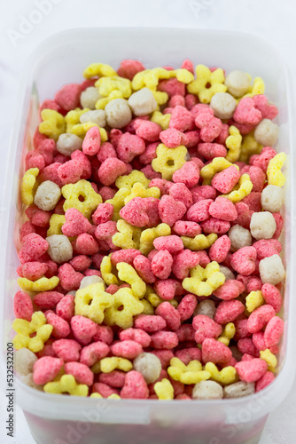 Corn snacks in the shape of hearts, flowers and balloons close-up. Quick breakfast cereal