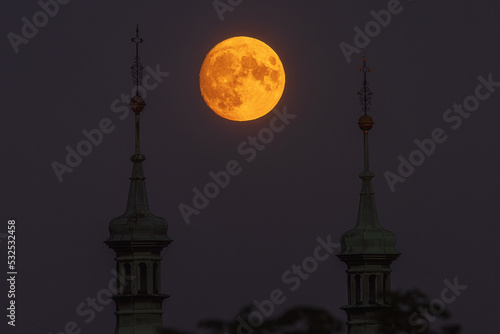 super full moon just after rising between the two towers of the church