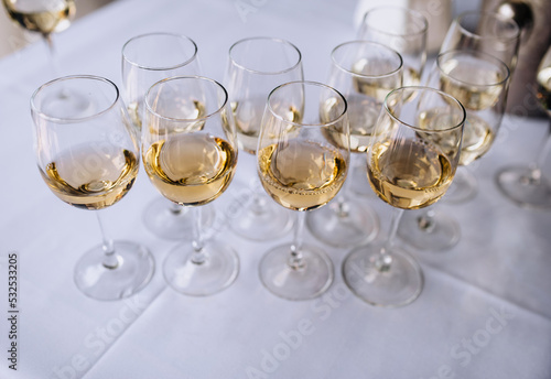 A lot, a row of glass glasses with champagne stands on a table in a bar, restaurant. Close-up photography, party.