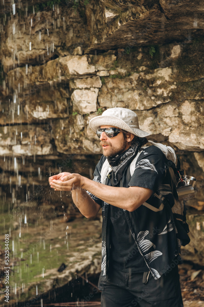 Male backpacker drinking clean water near cliff Male backpacker drinking clean water near cliff