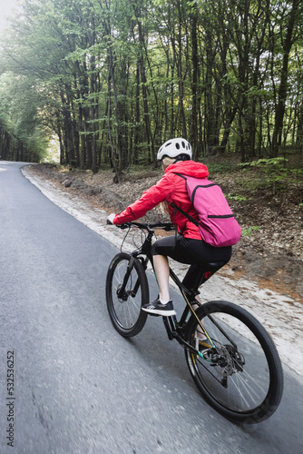 Female cyclist riding on bike photo