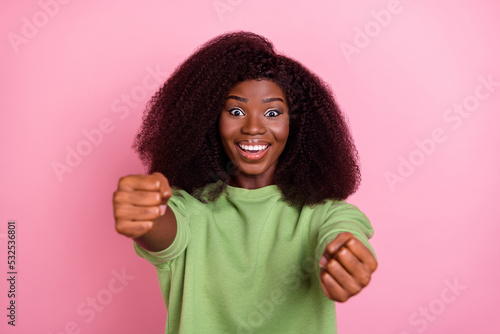 Photo of cheerful satisfied person arms hold imagine wheel toothy smile isolated on pink color background