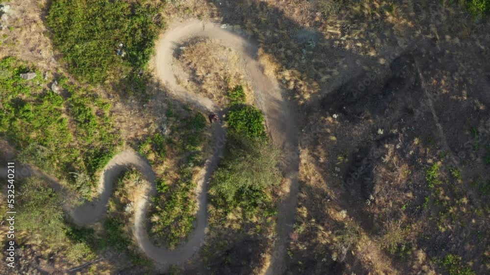 Aerial top down of mountain biker riding switchbacks Aerial top down of mountain biker riding switchbacks