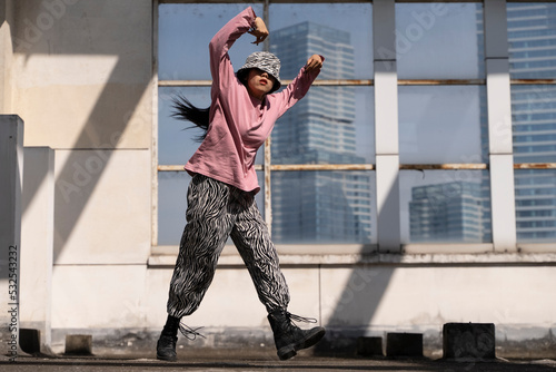 young woman hip hop dance on the roof photo