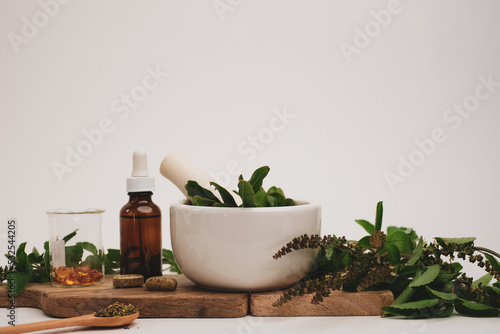 herbal medicine with pestle and mortar.capsule, oil, and tablet form with fresh herbal. Health and wellness concept photo
