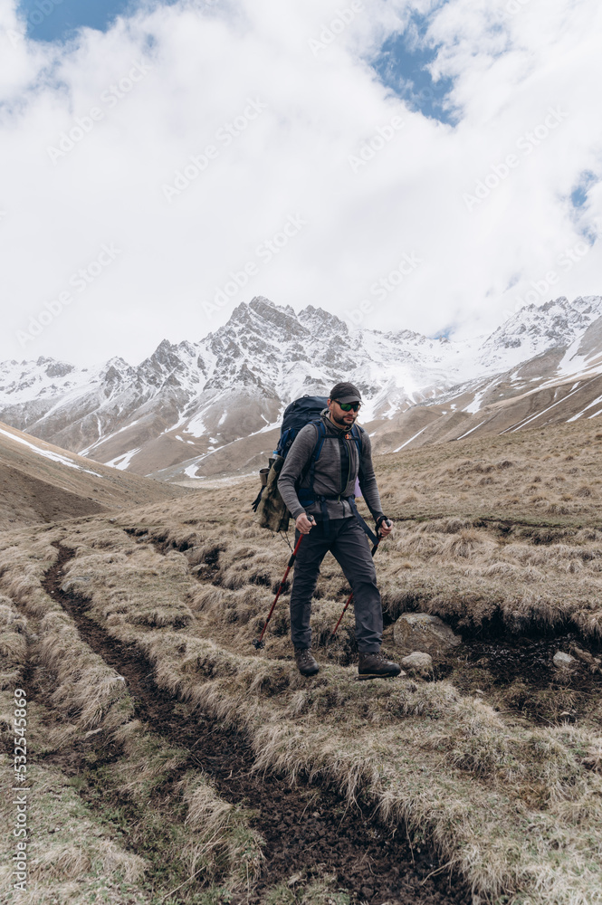 Traveler walking on rough ground near mountains Traveler walking on rough ground near mountains