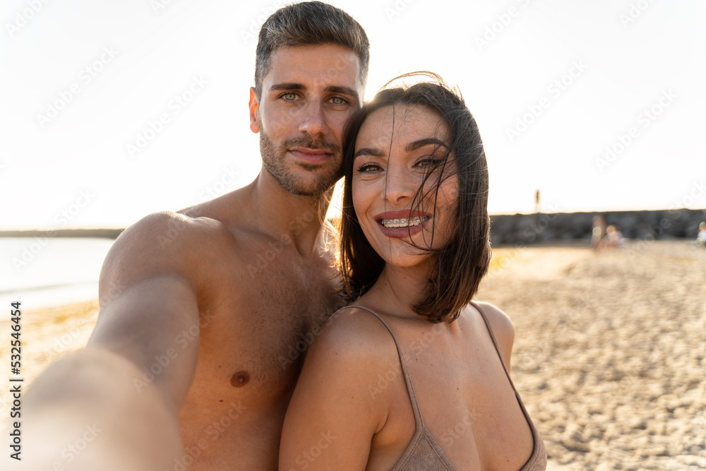 Romantic young couple enjoying summer vacation. Cheerful husband and beautiful wife during honeymoon spending time together at the beach. Romantic young couple enjoying summer vacation. Cheerful husband and beautiful wife during honeymoon spending time together at the beach.