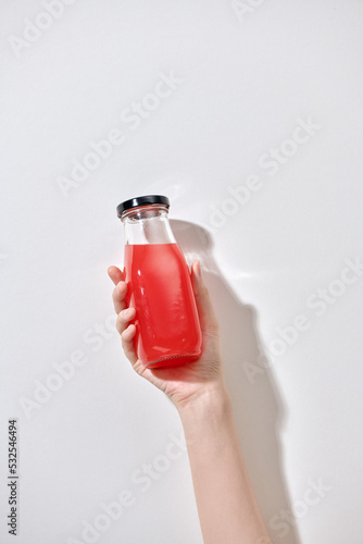 Hand hold red drink healthy drink in a bottle photo