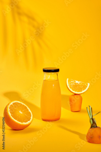 carrot and orange fresh juice on yellow table - food and drink photo