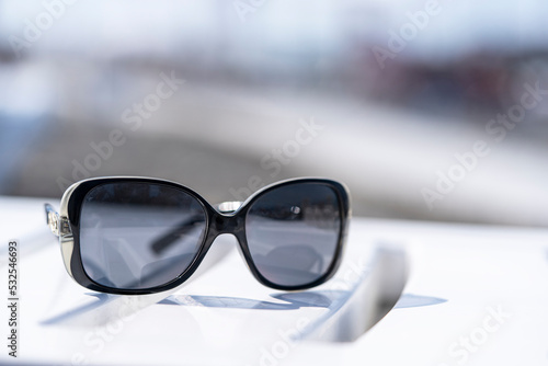 Sunglasses on a white sunbed for sunbathing