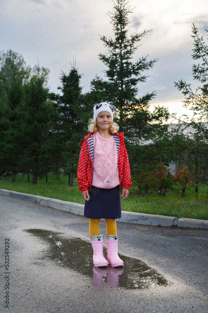 Content cute kid standing on wet road Content cute kid standing on wet road