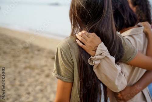 Arms wrapping around friends while at the beach
