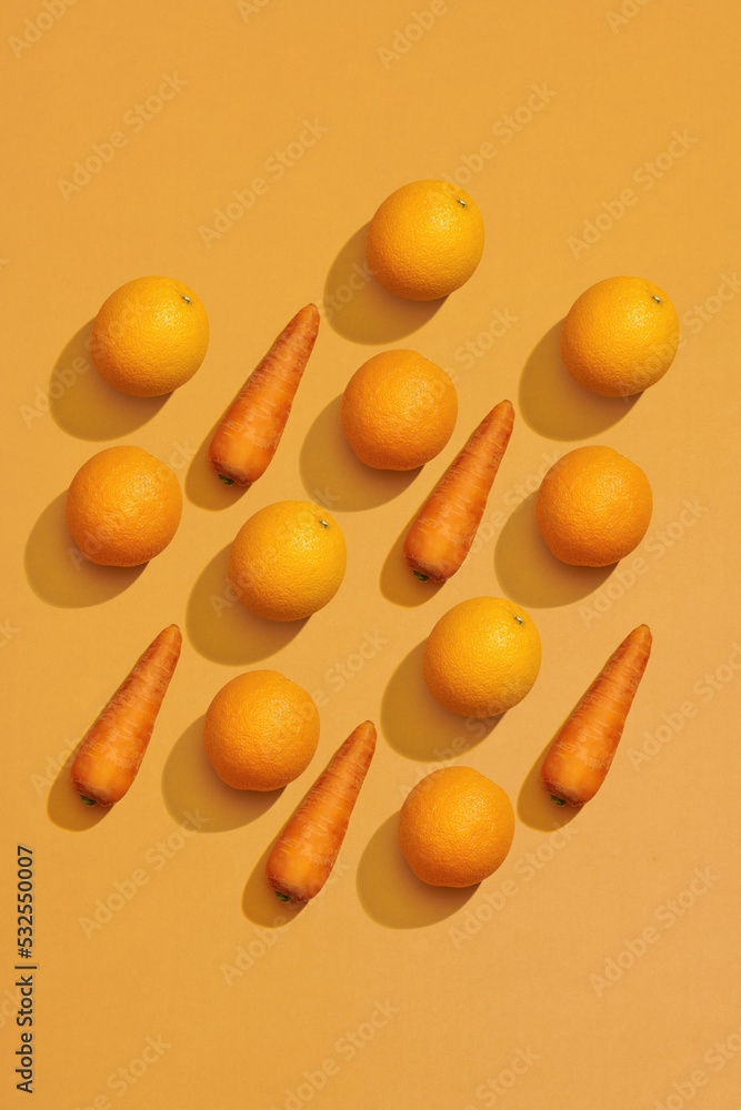 Fresh carrot and orange isolated on yellow background, healthy Fresh carrot and orange isolated on yellow background, healthy