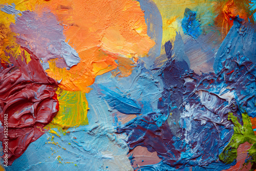 Colorful abstract texture. Smears of oil paint and a palette knife on an art palette. The concept of the modern school of art. Fragment of creative work. Colors of the year 2023.
