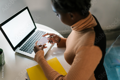 Black woman making online purchase on laptop photo