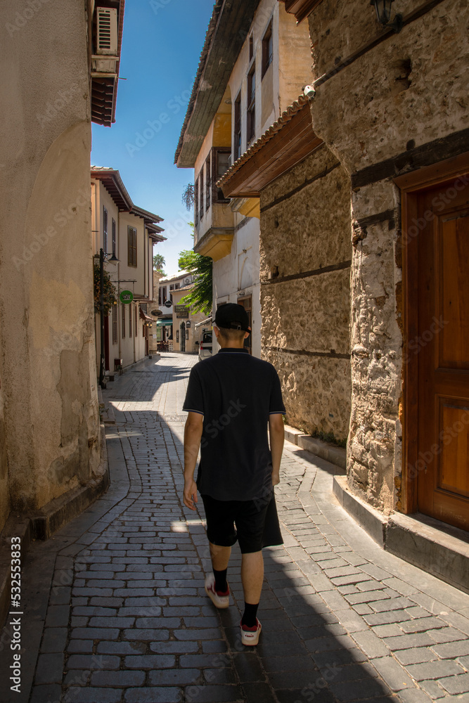 A young tourist walks through the old streets of Antalya in Turkey.