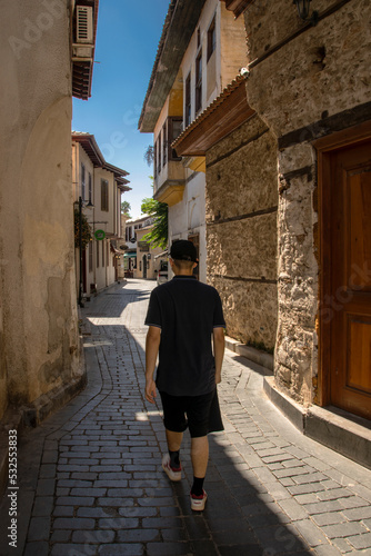 A young tourist walks through the old streets of Antalya in Turkey. © index74