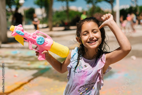 Cheerful girl with water pistol on street photo