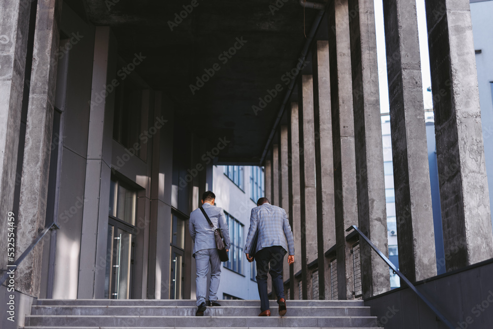 Men walking up staircase Men walking up staircase