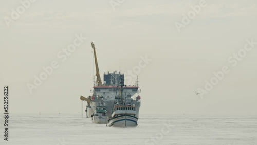 Sand dredger and fishing boat returning from the sea
