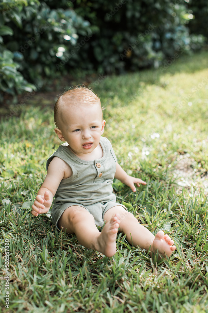 Happy Baby boy sitting on the grass Happy Baby boy sitting on the grass