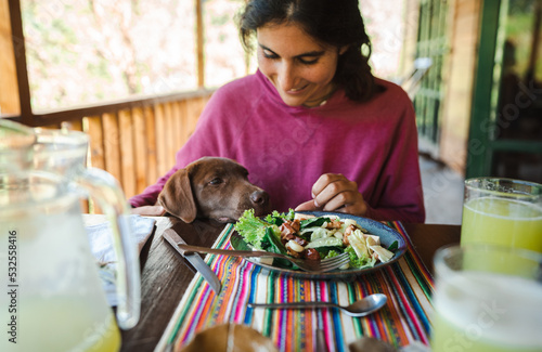 woman eating with her dog photo