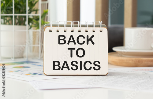 BACK TO BASICS text written on a notebook on table
