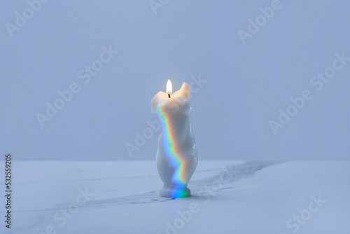Burning candle with incident rainbow.